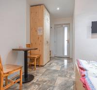 Predaj Exkluzívna ponuka elegantného penziónu s hostincom - Izba v hoteloch a penziónoch s dlažbou, dreveným stolom, stoličkami, TV a posteľou.