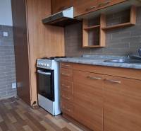 REZERVOVANÉ 2-izbový byt s nádherným výhľadom v pôvodnom stave   - Kuchyňa v 2-izbovom byte s dreveným dekorom podlahy a zabudovanými skriňami.