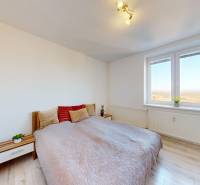 ZREKONŠTRUOVANÝ 3-IZBOVÝ BYT (74 m2) S BALKÓNOM, PIVNICOU, 2 x WC - Svetlá spálňa s podlahou s dreveným dekorom a veľkým oknom v 3-izbovom byte.