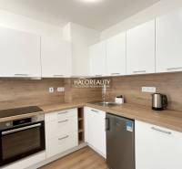 Prenájom, jednoizbový byt Banská Bystrica, Fončorda,... - Kuchyňa v 1-izbovom byte s podlahou s dreveným dekorom a bielymi skrinkami.