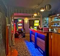 Na predaj unikátna dvojpodlažná budova na podnikanie aj bývanie - Interiér budovy s hracími automatmi, pultom a nápojmi na policiach.