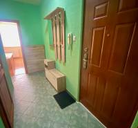 REZERVOVANÝ / NA PRENÁJOM 3 - IZB. BYT s LOGGIOU, SENICA - Chodba so zelenými stenami, dlažbou, vešiakom a skrinkami v 3-izbovom byte.