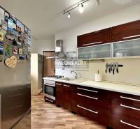 Predaj, trojizbový byt Levice, Rybníky III, po rekon... - Kuchyňa v 3-izbovom byte s podlahou s dreveným dekorom a spotrebičmi.