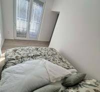 PREDAJ: 2 izbový tehlový byt-komplet.rek. - KOMÁRNO - Svetlá spálňa v 2-izbovom byte s dekoračnými vankúšmi a podlahou s dreveným dekorom.