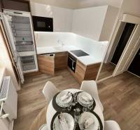 PREDAJ: 2 izbový tehlový byt-komplet.rek. - KOMÁRNO - Kuchyňa v 2-izbovom byte s podlahou s dreveným dekorom a jedálenským stolom.