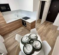 PREDAJ: 2 izbový tehlový byt-komplet.rek. - KOMÁRNO - Kuchyňa v 2-izbovom byte s podlahou s dreveným dekorom a jedálenským stolom.