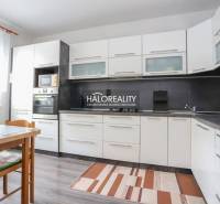 REZERVOVANÉ - Predaj, trojizbový byt Považská Bystri... - Kuchyňa v 3-izbovom byte s bielymi skrinkami a podlahou s dreveným dekorom.