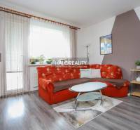 REZERVOVANÉ - Predaj, trojizbový byt Považská Bystri... - Obývacia izba v 3-izbovom byte s oranžovou sedačkou a podlahou s dreveným dekorom.