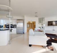 Veľkorysý 5-izbový byt v obľúbenej lokalite - Staré Grunty - Moderná obývacia izba s podlahou s dreveným dekorom a otvorenou kuchyňou v 5 a viac izbovom byte.