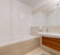 Veľkorysý 5-izbový byt v obľúbenej lokalite - Staré Grunty - Kúpeľňa v 5 a viac izbovom byte s vaňou a umývadlom, obklady a veľké zrkadlo.