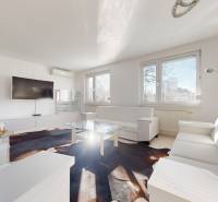 Veľkorysý 5-izbový byt v obľúbenej lokalite - Staré Grunty - Obývačka s bielym nábytkom, televízorom a preskleným stolom v 5 a viac izbovom byte.