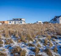 Stavebný pozemok v lokalite Medzi Vodami - Pozemky - bývanie v Mlynici s výhľadom na zasnežené hory a rodinné domy.