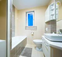 Predaj, dvojizbový byt Považská Bystrica - Kúpeľňa s vaňou a umývadlom v 2-izbovom byte, dominuje svetlá dlažba.