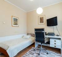 4-izbový byt, Štúrovo nábrežie Spišská Nová Ves - Izba v 4-izbovom byte s posteľou, pracovným stolom a televízorom na stene.