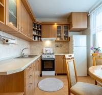 4-izbový byt, Štúrovo nábrežie Spišská Nová Ves - Kuchyňa so svetlým nábytkom, podlaha s dreveným dekorom, jedálenský stôl.