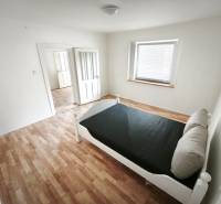 Rodinný dom - Lúčnica nad Žitavou  - Svetlá izba s posteľou, podlaha s dreveným dekorom, v rodinnom dome.