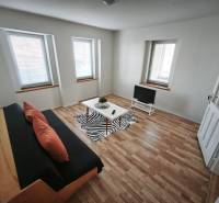 Rodinný dom - Lúčnica nad Žitavou  - Obývacia izba v rodinnom dome s pohovkou, televíziou a podlahou s dreveným dekorom.