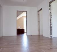 Na predaj – veľkorysý rodinný dom s úžasným výhľadom a pozemkom - Interiér rodinného domu s podlahou s dreveným dekorom a nezakrytými stavebnými otvormi.