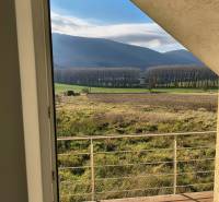 Na predaj – veľkorysý rodinný dom s úžasným výhľadom a pozemkom - Výhľad z rodinného domu v Bukovej ponúka pôsobivé lesy a polia za zábradlím.