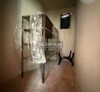 Predaj, rodinný dom Chynorany - EXKLUZÍVNE HALO REALITY - Úzka skladová miestnosť s regálmi a plastovým obalom v rodinnom dome.