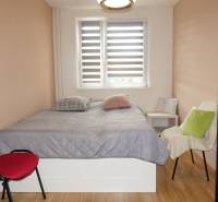 PREDAJ- 3-iz. byt, Homolova - Dúbravka, 67 m2, 11./12. posch., lodžia - Spálňa v 3-izbovom byte s posteľou, kreslami a podlahou s dreveným dekorom.