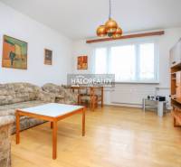 Predaj, trojizbový byt Považská Bystrica, Rozkvet - ... - Obývacia izba v 3-izbovom byte s podlahou s dreveným dekorom, sedačkou a nábytkom.