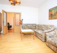 Predaj, trojizbový byt Považská Bystrica, Rozkvet - ... - Obývacia izba 3-izbového bytu s pohovkou, stolom a podlahou s dreveným dekorom.