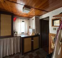 RODINNÝ DOM - CHALUPA, KALŠA - Interiér rodinného domu s dreveným stropom a závesmi, útulný kútik s dekoračnými prvkami.