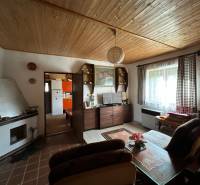 RODINNÝ DOM - CHALUPA, KALŠA - Obývacia izba v rodinnom dome s dreveným dekorom stropu a útulným nábytkom.