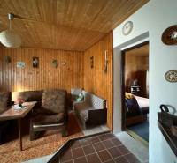 RODINNÝ DOM - CHALUPA, KALŠA - Interiér rodinného domu s dreveným obkladom a pohodlným nábytkom s retro dekoráciami.