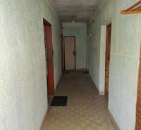 Predaj rodinného domu s pozemkom v  lukratívnej časti mesta Bratislava - Chodba v rodinnom dome so svetlo zelenými stenami, dlažbou a jednoduchým osvetlením.