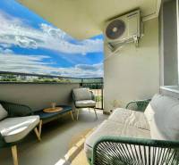 Na predaj štýlový 2-izbový byt s loggiou a parkovaním – TN, Na Pažiti - Útulný balkón s posedením, výhľadom a klimatizačnou jednotkou v 2-izbovom byte.