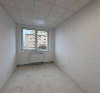 Prenájom nových kancelárskych priestorov a skladov na Teplickej ulici  - Biela kancelária s radiátorom a výhľadom cez okno.