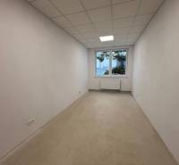 Prenájom nových kancelárskych priestorov a skladov na Teplickej ulici  - Prázdna kancelária s bielymi stenami a stropom, podlaha s dreveným dekorom.