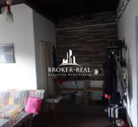 Rodinný dom Rudabanya, Maďarsko - Interiér rodinného domu so sedačkou a vešiakom, obložená stena v pozadí.