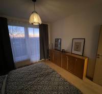 PRENÁJOM - Moderný 2 izbový byt, Galanta-GALA Residence - Spálňa s komodou a lampou, podlaha s dreveným dekorom v 2-izbovom byte.