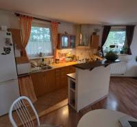 Na prenájom 3 izbový byt z balkónom a parkovacím miestom - Kuchyňa v 3-izbovom byte s podlahou s dreveným dekorom a jedálenským stolom.