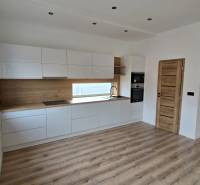 DOLINKY - Moravany nad Váhom 5 izbový bungalov - Kuchyňa s bielymi skrinkami a dreveným dekorom v rodinnom dome, podlaha s dreveným dekorom.