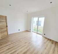 DOLINKY - Moravany nad Váhom 5 izbový bungalov - Interiér Rodinného domu s podlahou s dreveným dekorom a veľkým oknom na záhradu.