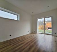 DOLINKY - Moravany nad Váhom 5 izbový bungalov - Interiér rodinného domu s podlahou s dreveným dekorom a veľkým oknom.