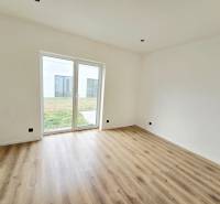 DOLINKY - Moravany nad Váhom 5 izbový bungalov - Interiér rodinného domu s bielymi stenami, podlahou s dreveným dekorom a veľkým oknom.