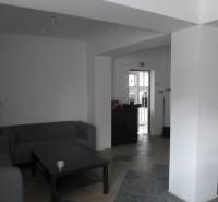 Sklad na prenájom o ploche 288 m2-438 m2 + kancelárie a vzorkovňa - Obývací priestor so sivými pohovkami, stolíkom a dlaždicovou podlahou v Skladoch a halách.