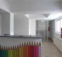Sklad na prenájom o ploche 288 m2-438 m2 + kancelárie a vzorkovňa - Interiér Sklady a haly s recepčným pultom zdobeným farebnými ceruzkami a požiarnym hydrantom.
