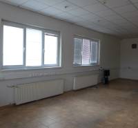 Sklad na prenájom o ploche 288 m2-438 m2 + kancelárie a vzorkovňa - Prázdna miestnosť so stenovými radiátormi a dlažbou v skladoch a halách.