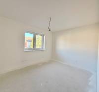 NOVOSTAVBA  ATRAKTÍVNY 4 I RODINNÝ DOM,650m2 pozemok - Priestranná, svetlá izba v rodinnom dome s dvojitým oknom a bielymi stenami.