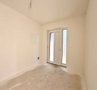 NOVOSTAVBA  ATRAKTÍVNY 4 I RODINNÝ DOM,650m2 pozemok - Prázdna miestnosť s francúzskymi dverami v rodinnom dome, biele steny, betónová podlaha.