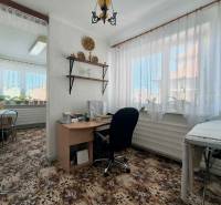 ‼️RODINNÝ DOM S KRÁSNYM POZEMKOM NA PREDAJ,KOLAČNO okr. PARTIZÁNSKE ‼️ - Izba v rodinnom dome s písacím stolom, rastlinami a kobercom s kvetinovým vzorom.