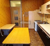 REZERVOVANÉ - Predaj, trojizbový byt Krompachy, Slov... - Kuchyňa v 3-izbovom byte s podlahou s dreveným dekorom, stolom a vstavanou lavicou.