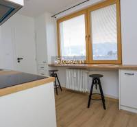 Prenájom, dvojizbový byt Považská Bystrica, Tatransk... - Kuchyňa v 2-izbovom byte s bielymi skrinkami a podlahou s dreveným dekorom.