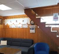 Predaj, chata Byšta - EXKLUZÍVNE HALO REALITY - Interiér chaty s dreveným obkladom, schodmi, sedačkou a dekoráciami na stenách.